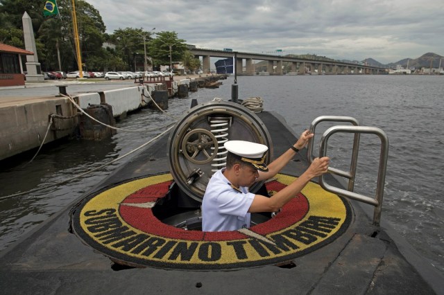 Brazilian Navy Captain, Jose Americo Alexandre Dias, climbs the hatch of the Brazilian submarine Timbira, during a presentation to the press in Rio de Janeiro, Brazil, on November 22, 2017, whilst other vessels and aircrafts of the Brazilian Navy are taking part in the international search mission for missing Argentine submarine ARA San Juan.  An international search mission for a missing Argentine submarine entered a critical phase Tuesday after nearly a week without signs of life -- as the vessel risked running out of oxygen after being submerged for so long. The ARA San Juan would have enough oxygen for its crew to survive underwater for seven days, if there was no hull breach, according to officials. At 0730 GMT Wednesday, that time will have elapsed.  / AFP PHOTO / LEO CORREA / ?The erroneous mention[s] appearing in the metadata of this photo by LEO CORREA has been modified in AFP systems in the following manner: [whilst other vessels and aircrafts of the Brazilian Navy are taking part in the international search mission for missing Argentine submarine ARA San Juan.] instead of [which takes part in the international search mission for the missing Argentine submarine ARA San Juan]. Please immediately remove the erroneous mention[s] from all your online services and delete it (them) from your servers. If you have been authorized by AFP to distribute it (them) to third parties, please ensure that the same actions are carried out by them. Failure to promptly comply with these instructions will entail liability on your part for any continued or post notification usage. Therefore we thank you very much for all your attention and prompt action. We are sorry for the inconvenience this notification may cause and remain at your disposal for any further information you may require.?