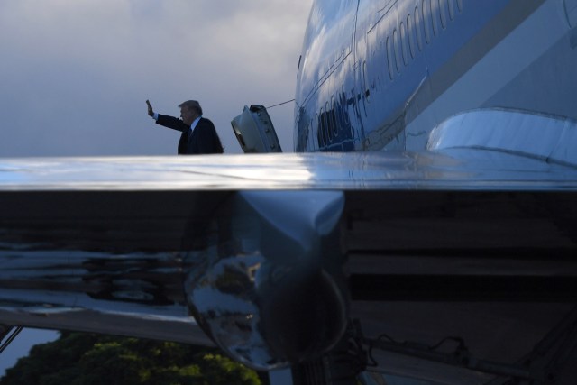 US President Trump waves as he embarks on Air Force One leaving Hawaii for Japan on November 04, 2017. After stopping in Hawaii to pay his respects at a Pearl Harbor memorial, US President Donald Trump reboarded Air Force One on Saturday for a marathon Asia tour as North Korea's nuclear threat looms large. / AFP PHOTO / JIM WATSON