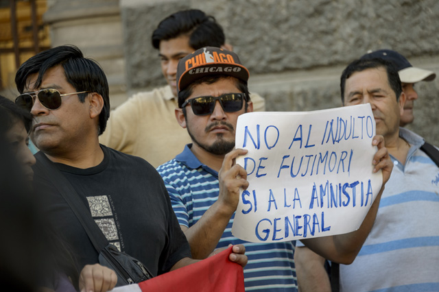 Peruvian citizens living in Chile hold a protest against Peruvian President Pedro Pablo Kuczynski's humanitarian pardon to Peru's jailed ex-president Alberto Fujimori, in Santiago, Chile on December 25, 2017.  Kuczynski on Sunday granted a humanitarian pardon to ex-president Fujimori, who has been hospitalized since Decembre 23 and is serving a 25-year sentence for crimes against humanity. / AFP PHOTO / MARTIN BERNETTI