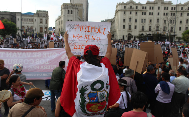 People hold a protest against Peruvian President Pedro Pablo Kuczynski's humanitarian pardon to Peru's jailed ex-president Alberto Fujimori, in Lima on December 25, 2017.  The president of Peru, Pedro Pablo Kuczynski, on Sunday granted humanitarian pardon to ex-president Alberto Fujimori, who has been hospitalized since December 23 and is serving a 25-year sentence for crimes against humanity. / AFP PHOTO / Juan Vita
