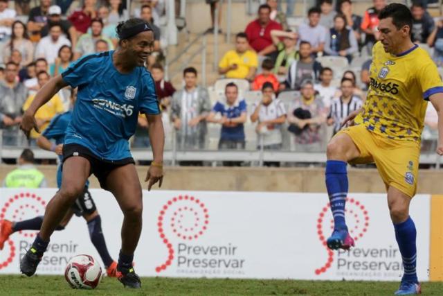 El futbolista brasileño Ronaldinho Gaúcho (i) disputa el balón con Lucio (d) durante un partido benéfico en el estadio Mineirão, en Belo Horizonte (Brasil). EFE