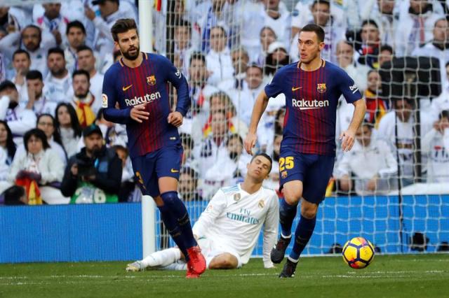 El jugador del Real Madrid Cristiano Ronaldo,c., y los defensas del FC Barcelona Gerard Piqué,iz., y Thomas Vermaelen,d., ,durante el partido correspondiente a la jornada 17 de Liga en Primera División que el Real Madrid y el FC Barcelona, disputaron hoy en el estadio Santiago Bernabéu. EFE/Juan Carlos Hidalgo