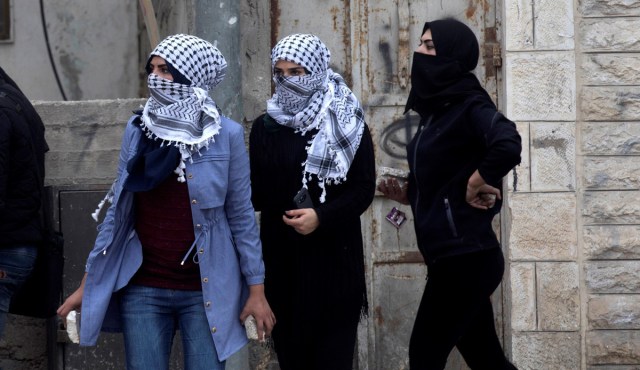 ATS09. QALANDIA (GAZA Y CISJORDANIA), 20/12/2017.- Mujeres palestinas sostienen piedras durante enfrentamientos con las fuerzas israelíes en el puesto de control militar israelí de Qalandia, hoy, 20 de diciembre de 2017. Miles de palestinos marcharon hoy desde Ramala hasta Qalandia, donde se registraron fuertes disturbios entre soldados y manifestantes, que protestaban por la declaración del presidente de EEUU, Donald Trump, sobre Jerusalén. EFE/ Atef Safadi