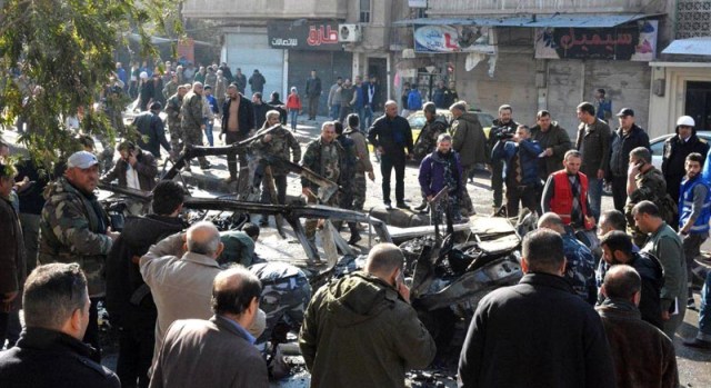 EPA4533. HOMS (SIRIA), 05/12/2017.- Varios curiosos rodean varios vehículos destruidos tras la explosión de un microbús en la ciudad de Homs (Siria) hoy, 5 de diciembre de 2017. Al menos ocho personas murieron y varias resultaron heridas en el suceso, según el Observatorio Sirio de Derechos Humanos. EFE/SANA SOLO USO EDITORIAL NO VENTAS MEJOR CALIDAD DISPONIBLE FOTO CEDIDA
