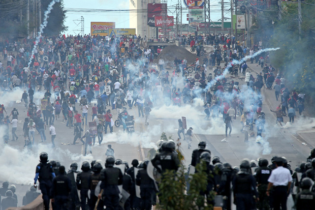 REFILE - CORRECTING GRAMMAR Demonstrators clash with riot police and soldiers during a protest as Honduran President Juan Orlando Hernandez is sworn in for a new term in Tegucigalpa, Honduras January 27, 2018. REUTERS/Edgard Garrido