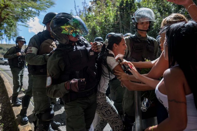 CAR014. CARACAS (VENEZUELA), 20/01/2018. Miembros de la Guardia Nacional Bolivariana (GNB) custodian una parcela del Cementerio del Este y cercan el paso a familiares de José Díaz Pimentel y a Abraham Agostini hoy, sábado 20 de enero del 2018, en Caracas (Venezuela). Dos de las seis personas abatidas junto al exinspector alzado contra el Gobierno venezolano Óscar Pérez fueron enterrados hoy en medio de denuncias de que los familiares no autorizaron el sepelio, mientras continúa la incertidumbre sobre qué se hará con el cuerpo del líder del grupo. EFE/Miguel Gutiérrez