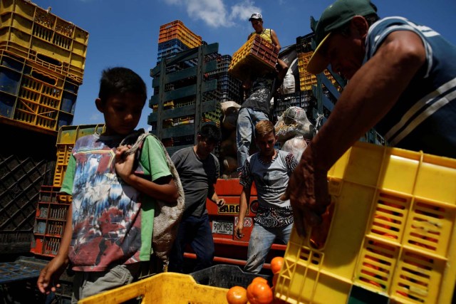 A child looks at a basket filled with mandarins while workers load merchandise into Humberto Aguilar's truck at the wholesale market in Barquisimeto, Venezuela January 30, 2018. REUTERS/Carlos Garcia Rawlins TPX IMAGES OF THE DAY SEARCH "LAWLESS ROADS" FOR THIS STORY. SEARCH "WIDER IMAGE" FOR ALL STORIES.?