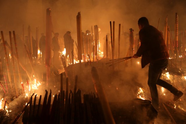 People burn incense sticks and pray for good fortune at Giant Buddhist Temple on the first day of the Chinese Lunar New Year of Dog, in Chongqing, China, February 16, 2018. Picture taken February 16, 2018. REUTERS/Stringer  ATTENTION EDITORS - THIS IMAGE WAS PROVIDED BY A THIRD PARTY. CHINA OUT.