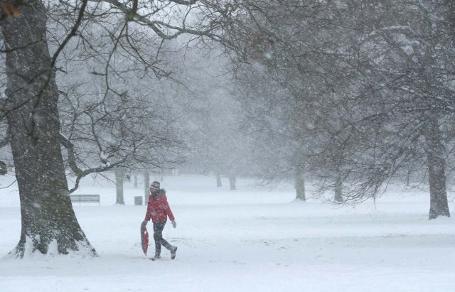 A woman walks through the snow Greenwich Park, London, Britain February 28, 2018. REUTERS/Hannah McKay