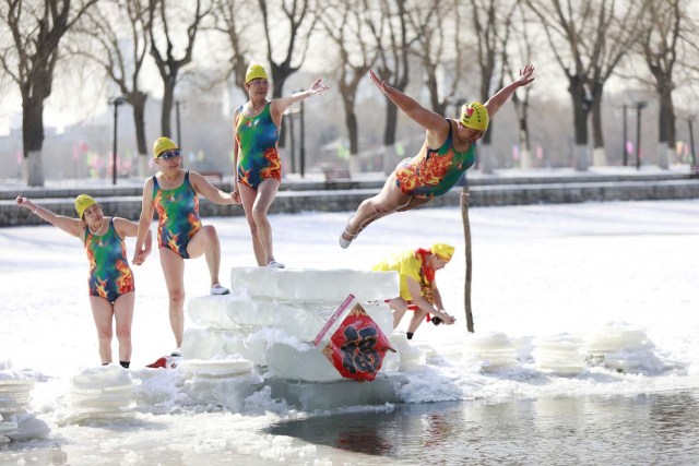 A woman dives into a partly frozen lake in Shenyang in China's northeastern Liaoning province on March 2, 2018. / AFP PHOTO / - / China OUT