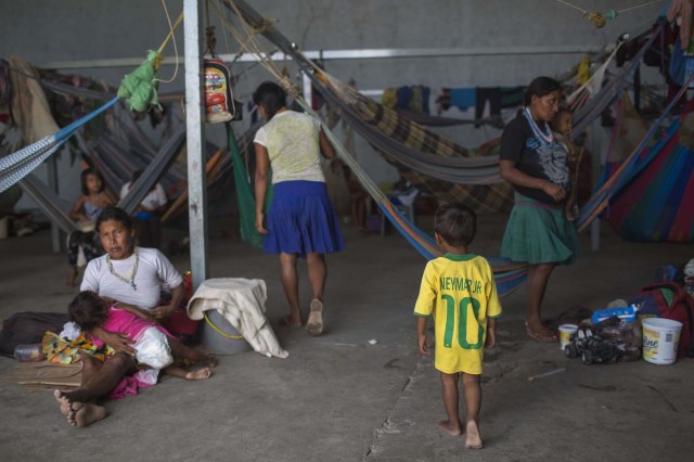 Venezuelan indigenous refugees rest inside a temporary shelter in the city of Pacaraima, Roraima, Brazil, on February 28, 2018. Hundreds of Venezuelan indigenous people, most of them Warao indigenous, from the northeast of the country, escaped from turmoil and hunger to Brazil during last years. In improvised shelters the situation has improved for some of them, but the migration increasing influx and the lack of plans generates uncertainty. / AFP PHOTO / Mauro Pimentel / TO GO WITH AFP STORY by Paula RAMÓN