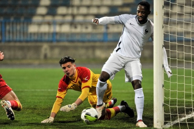 France's Moussa Dembele (R) vies with Montenegrin goalkeeper Matija Sarkic (L) during the Euro 2018 U-21 qualifying football match between Montenegro and France at Gradski Stadium in Niksic on March 27, 2018.  / AFP PHOTO / SAVO PRELEVIC
