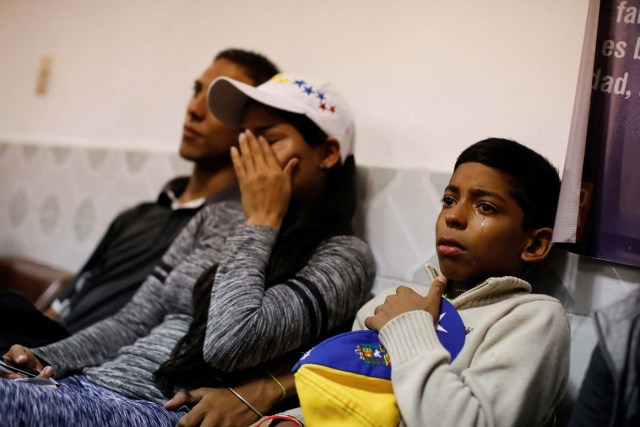 David Vargas (R), 12, cries as he sits next to his aunt after saying goodbye to relatives while he waits to board a bus to travel from Caracas to Guayaquil, at the Rutas de America's bus station in Caracas, Venezuela, November 7, 2017. The moment before getting on the bus was very sad, filled with silence, tension, hugs and tears. Carlos Garcia Rawlins: "It was very hard to see the disconsolate way David was crying, once he said goodbye to his loved ones and realized that he was about to start the journey to Chile". REUTERS/Carlos Garcia Rawlins SEARCH "RAWLINS BUS" FOR THIS STORY. SEARCH "WIDER IMAGE" FOR ALL STORIES.
