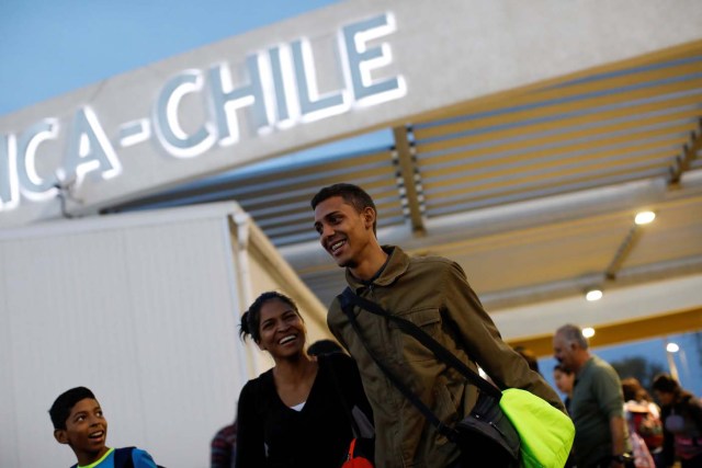 Adrian Naveda, Alejandra Rodriguez and her nephew David Vargas (R-L), traveling by bus from Caracas to Chile, smile after crossing the border between Peru and Chile at the migration office in Arica, Chile, November 13, 2017. Getting to Chile was the goal, but everyone was a little worried, because they knew this was the border where the authorities could ask them tricky questions. As they walked out of the migration office in Arica, happiness and a mood of "We made it!" took over, even though they still had two more days on the road ahead of them. REUTERS/Carlos Garcia Rawlins SEARCH "RAWLINS BUS" FOR THIS STORY. SEARCH "WIDER IMAGE" FOR ALL STORIES.