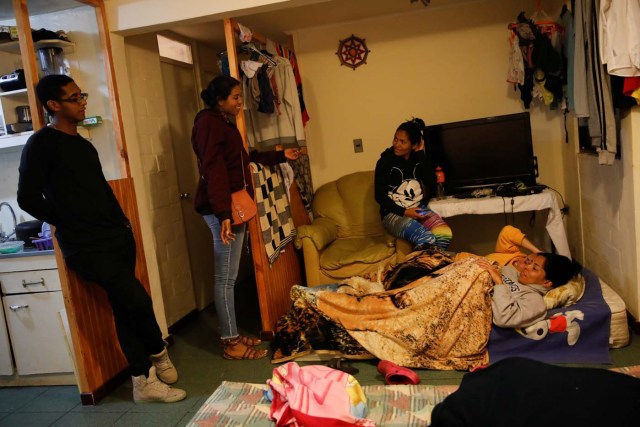Alejandra Rodriguez (C) and her sister Natacha Rodriguez (R), who travelled by bus from Venezuela to Chile, talk with their housemates as they prepare to sleep at their house in Concon, Chile, November 20, 2017. Natacha, her son David, her sister Alejandra and Adrian (a family friend), arrived at the small apartment rented by a group of Venezuelan friends. Even though they were already living in cramped conditions, they happily offered the newcomers a place to stay while they got on their feet. REUTERS/Carlos Garcia Rawlins SEARCH "RAWLINS BUS" FOR THIS STORY. SEARCH "WIDER IMAGE" FOR ALL STORIES.
