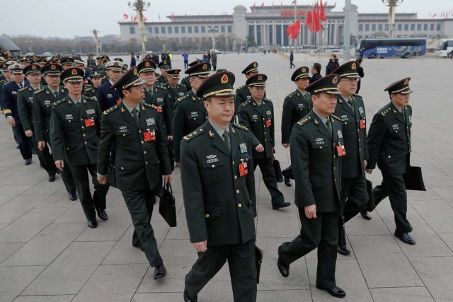 Military delegates arrive to the third plenary session of the National People's Congress (NPC) at the Great Hall of the People to take a part in a vote on a constitutional amendment lifting presidential term limits, in Beijing, China March 11, 2018. REUTERS/Damir Sagolj