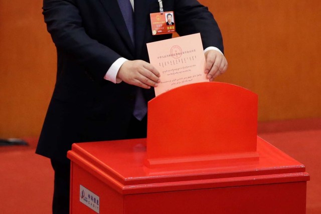 Chinese President Xi Jinping drops his ballot during a vote on a constitutional amendment lifting presidential term limits, at the third plenary session of the National People's Congress (NPC) at the Great Hall of the People in Beijing, China March 11, 2018. REUTERS/Jason Lee