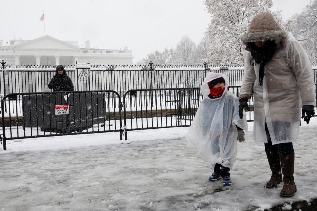 Tourists walk past the White House during a snowstorm in Washington, U.S., March 21, 2018. REUTERS/Yuri Gripas
