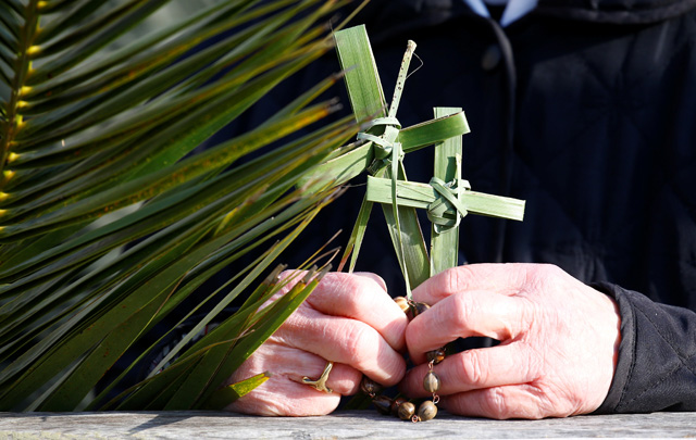 A nun holds crosses made of palm leaves during the Palm Sunday Mass in Saint Peter's Square at the Vatican, March 25, 2018 REUTERS/Stefano Rellandini