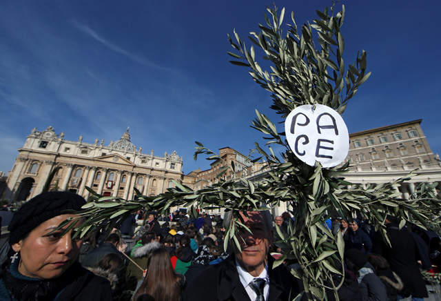 Faithful gather to attend the Palm Sunday Mass in Saint Peter's Square at the Vatican, March 25, 2018 Sign reads "Peace".  REUTERS/Tony Gentile