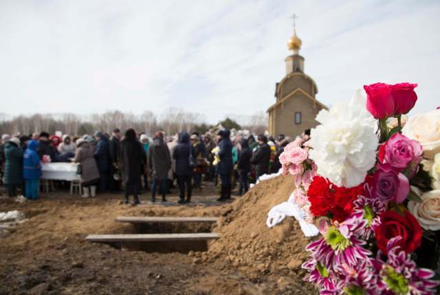 People attend a funeral of a victim of a shopping mall fire at a cemetery in Kemerovo, Russia March 28, 2018. REUTERS/Maxim Lisov