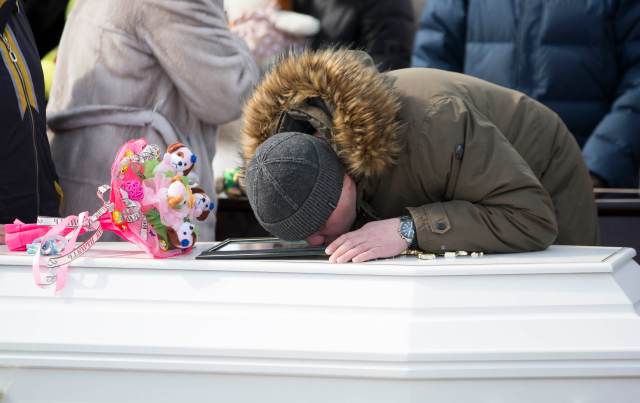 A man kisses a photo during a funeral of a victim of a shopping mall fire at a cemetery in Kemerovo, Russia March 28, 2018. REUTERS/Maxim Lisov