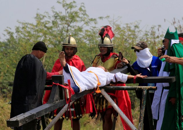 Mary Jane Sazon, 39, reacts after she was nailed on a wooden cross for the 7th time, during a Good Friday crucifixion re-enactment in Cutud village, Pampanga province, north of Manila, Philippines March 30, 2018. REUTERS/Romeo Ranoco