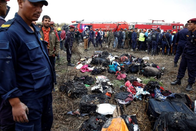 EPA6008. KATMANDÚ (NEPAL), 12/03/2018.- Miembros de los servicios de emergencia rodean parte del equipaje recuperado del avión que se estrelló en el aeropuerto de Katmandú (Nepal) hoy, 12 de marzo de 2018. Al menos 49 personas han muerto y 22 resultaron heridas en el accidente del avión de la línea bangladeshí US-Bangla con 67 pasajeros y 4 miembros de la tripulación a bordo. EFE/ Narendra Shrestha