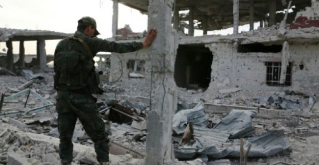 Un miembro de las fuerzas gubernamentales sirias observa la destrucción en Al Shifoniya el 4 de marzod e 2018, mientras continúa el avance en la región rebelde de Guta Orienta. AFP 