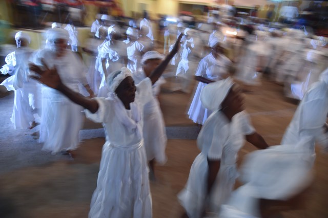 Haitian voodoo followers wearing white clothes participate in a voodoo ceremony in Souvenance, a suburb of Gonaives, 171km north of Port-au-Prince, on April 1, 2018. Haitian voodoo followers arrived in Souvenance to take part in the voodoo ceremonies held during Easter weekend. / AFP PHOTO / Hector RETAMAL