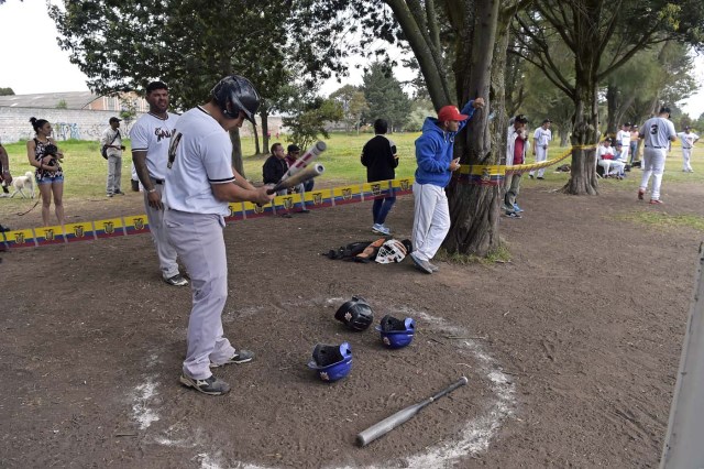 Venezuelan immigrants prepare to play softball during the inauguration of the Pichincha League Softball Championship, at Parque Bicentenario, in Quito on March 18, 2018. The increase in the number of Venezuelan immigrants in Ecuador leaded to growth of the softball league from four to 16 teams in the last years, with some 450 players in total. / AFP PHOTO / Rodrigo BUENDIA / TO GO WITH AFP STORY BY PAOLA LOPEZ
