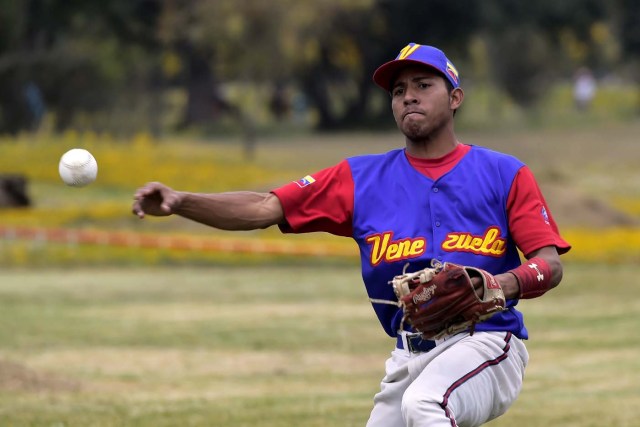 A Venezuelan immigrant plays softball during the inauguration of the Pichincha League Softball Championship, at Parque Bicentenario, in Quito on March 18, 2018. The increase in the number of Venezuelan immigrants in Ecuador leaded to growth of the softball league from four to 16 teams in the last years, with some 450 players in total. / AFP PHOTO / Rodrigo BUENDIA / TO GO WITH AFP STORY BY PAOLA LOPEZ
