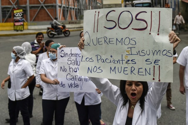 Health workers and patients protest for the lack of medicines, medical supplies and poor conditions in hospitals, in Caracas on April 17, 2018. Doctors and nurses protest against the health crisis in Venezuela, currently in the midst of a deep economic and political crisis and where health authorities have reported a rise in vaccine-preventable diseases. / AFP PHOTO / Luis ROBAYO