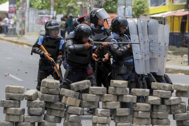 Agentes de la policía antidisturbios chocan con estudiantes frente a la Universidad de Ingeniería durante una protesta contra las reformas del gobierno en el Instituto de Seguridad Social (INSS) en Managua el 20 de abril de 2018. Un manifestante y un policía fueron asesinados en la capital nicaragüense, Managua, luego de que las manifestaciones por la reforma de las pensiones se volvieran violentas el jueves por la noche, dijeron las autoridades. Las muertes se produjeron después de las protestas de opositores y partidarios de una nueva ley, que aumenta las contribuciones de los empleadores y los empleados, mientras que reduce el monto total de las pensiones en un cinco por ciento, sacudió la capital por segundo día consecutivo. / AFP PHOTO / INTI OCON