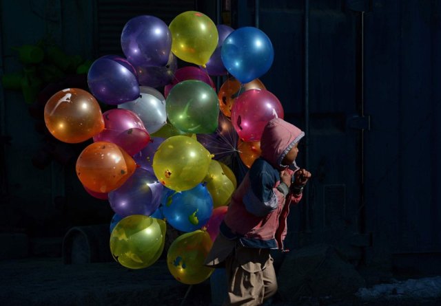 Un niño camina con globos en la ciudad afgana de Kabul, el 7 de febrero de 2013. SHAH MARAI AFP