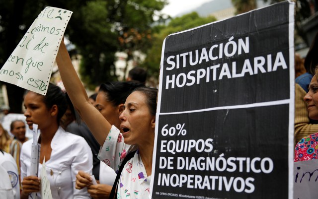 Workers of the health sector take part in a protest due to the shortages of basic medical supplies and for higher wages outside a children hospital in Caracas, Venezuela April 17, 2018. The placard reads, "Hospital situation. 60% diagnostic equipment out of service". REUTERS/Carlos Garcia Rawlins
