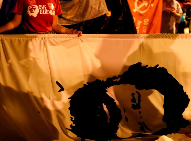 Un partidario del ex presidente brasileño Luiz Inácio Lula da Silva sostiene una bandera con la cara de Lula en un campamento cerca de la sede de la Policía Federal, donde Lula está preso, en Curitiba, Brasil, el 13 de abril de 2018. Fotografía tomada el 13 de abril de 2018. REUTERS / Rodolfo Buhrer