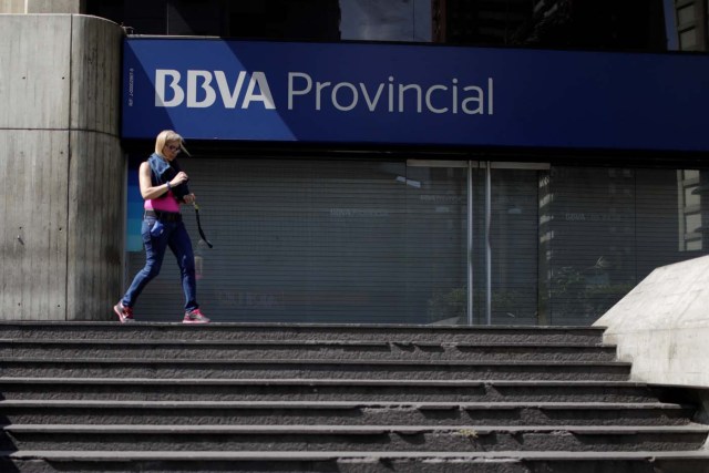 A woman walks outside a branch of BBVA Provincial bank in Caracas, Venezuela April 6, 2018. Picture taken April 6, 2018. REUTERS/Marco Bello