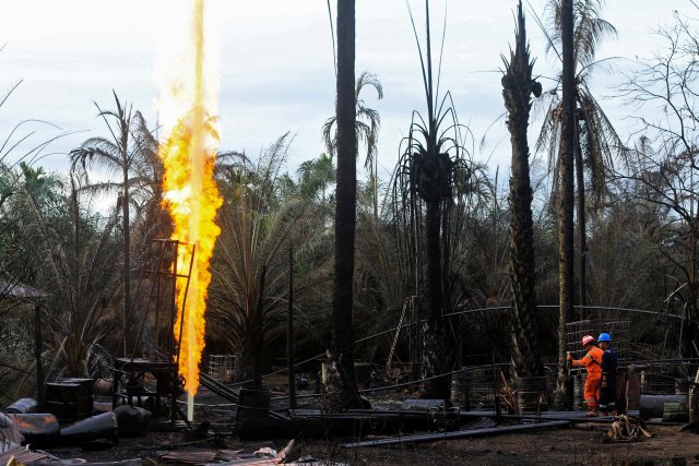 Funcionarios de la petrolera estatal Pertamina examinan un incendio en un pozo de petróleo ilegal en Ranto Peureulak, provincia de Aceh, Indonesia, el 26 de abril de 2018 en esta foto tomada por Antara Foto. Antara Foto / Rahmad / vía EDITORES DE ATENCIÓN DE REUTERS 