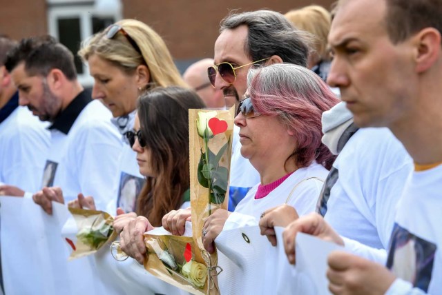 Angelique's mother (2ndR), father (3rdR) and sister Anais (4thR), take part in a march in Wambrechies, northern France, on May 1, 2018, in tribute to Angelique, a 13-year-old girl who was killed and raped on April 25. The body of Angelique, who had disappeared since April 25, was found in the night from April 28 to April 29 in the countryside in Quesnoy-sur-Deule, northern France. David Ramault, 45 years old, who confessed the crime, was arrested in the night from April 30 to May 1 for kidnapping, rape and murder on minor under 15 years / AFP PHOTO / PHILIPPE HUGUEN
