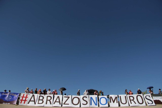 Mexican families wait to meet with their relatives living in US and coming to the border line in the bank of Rio Grande to take part in the event called "Abrazos No Muros" (Hugs, not walls) promoted by the Border Network of Human Rights organization in the border line between El Paso, Texas, United States and Ciudad Juarez, Chihuahua state, Mexico on May 12, 2018. / AFP PHOTO / HERIKA MARTINEZ