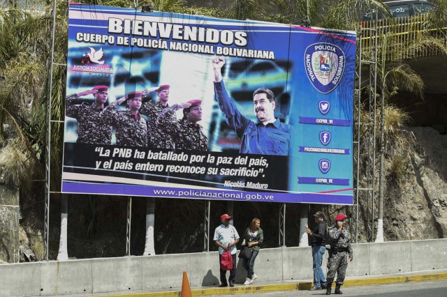 A poster with an image of Venezuela President Nicolas Maduro (R) is seen at the entrance of El Helicoide, the headquarters of the Bolivarian National Intelligence Service (SEBIN), in Caracas, on May 17, 2018, where Venezuelan opponents and a US citizen have seized control of the detention centre. The Venezuelan opponents and a US Mormon missionary, who took control of the cell block area on the eve, are demanding the release of prisoners, according to videos broadcast on social networks. / AFP PHOTO / Juan BARRETO