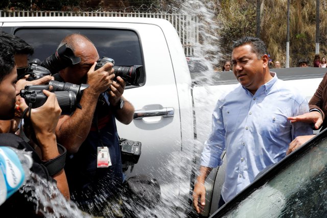Venezuelan presidential candidate Javier Bertucci of the "Esperanza por el Cambio" party reacts after an inmate's relative throws water, outside a detention centre of the Bolivarian National Intelligence Service (SEBIN) in Caracas, Venezuela May 17, 2018. REUTERS/Carlos Jasso