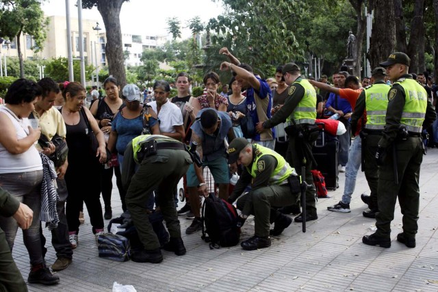 Colombian police officers frisk people and inspect their luggage as Venezuelans queue outside an exchange house in Cucuta, Colombia May 17, 2018. Picture taken May 17, 2018. REUTERS/Carlos Eduardo Ramirez