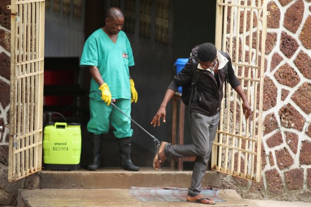 FOTO DEL ARCHIVO: Un trabajador de salud rocía a un visitante con cloro después de salir de la instalación de aislamiento, preparado para recibir casos sospechosos de ébola, en el Hospital General de Mbandaka, en Mbandaka, República Democrática del Congo el 20 de mayo de 2018. REUTERS / Kenny Katombe / File Photo