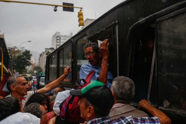 CAR100. CARACAS (VENEZUELA), 16/05/2018.- Usuarios intentan abordar unidades de transporte este martes, 15 de mayo de 2018, en Caracas (Venezuela). El colapso del transporte suburbano ha aislado esta última semana a las localidades de Guarenas y Guatire, dos ciudades dormitorio a menos de una hora de la capital de Venezuela que entran así a la espiral de caos en la que ya están inmersas diversas ciudades del país por la escasez de unidades. EFE/Cristian Hernández