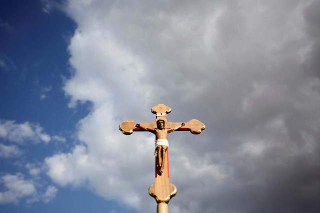 FILE PHOTO: A pilgrim holds a crucifix before a Marian Vespers ceremony celebrated by Pope Benedict XVI in Etzelsbach, Germany, September 23, 2011.The Bavarian-born pontiff is on a four-day visit to Germany, his third visit to his homeland since he took over as head of the Catholic church. REUTERS/Kai Pfaffenbach/File Photo