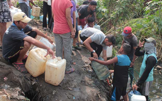Desesperados, en Maracaibo recogen agua sucia de una quebrada