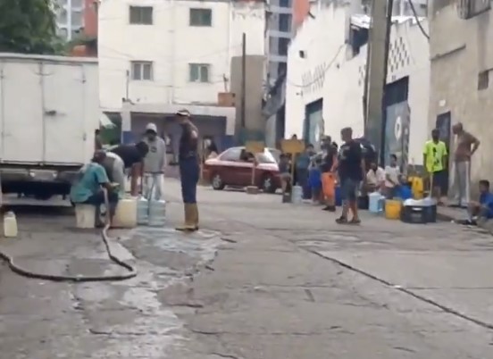 Sin mascarillas ni distanciamiento: Caraqueños hicieron cola para recoger agua en un hidrante (VIDEO)